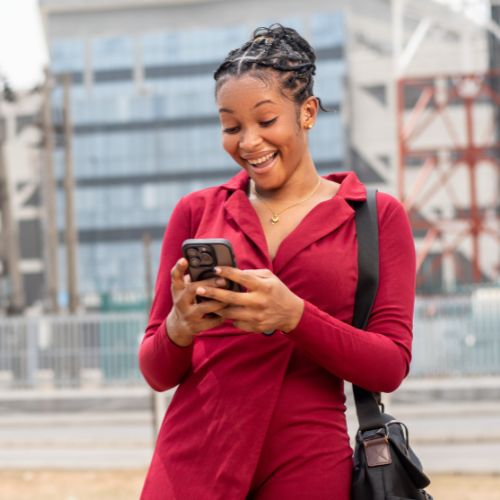 black woman smiling looking at her phone